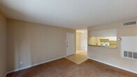 Located in Conroe, TX, this single-floor, 1-bedroom, 1-bathroom unit offers a well-organized layout designed for comfortable everyday living. The living area features neutral-toned carpet and warm beige walls, creating a cozy atmosphere. A pass-through opening connects the living space to the kitchen, enhancing the open feel. The kitchen is designed in a galley style, equipped with white cabinetry, a coil electric range, a refrigerator, and a sink with laminate countertops, all set on light ceramic tile flooring. A tiled entryway leads from the front door into the main living space, providing a clean transition point. The living room also features a sliding glass door dressed with vertical blinds, allowing for natural light and outdoor access. The bedroom is generously sized with plush carpet, a ceiling fan with integrated lighting, and a window that brings in additional natural light. The bathroom includes a full tub and shower combination with white square tile surround, a toilet, and overhead cabinetry for storage. Throughout the unit, clean white trim and consistent neutral finishes contribute to a cohesive and functional living environment.