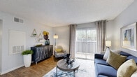 Located at 12801 Roydon Dr in Houston, TX, this single-floor, one-bedroom, two-bathroom home offers a thoughtfully arranged layout across a comfortable footprint. The living room serves as the central gathering space, featuring wood-style flooring, a textured ceiling, and a large sliding glass door flanked by vertical blinds that flood the room with natural light and provide direct access to the private patio. A dedicated dining area with wainscoting detail and a window adds a refined touch to the open flow between spaces. The kitchen is well-appointed with white cabinetry, light countertops, and black appliances, including a full-size refrigerator and dishwasher, all set atop matching wood-style flooring. The bedroom is a comfortable retreat with plush carpet, a ceiling fan, natural light from a window with blinds, and access to a dedicated closet. Two bathrooms serve the home — one featuring a wide vanity with white cabinetry, a large mirror, and wood-style flooring, and the other offering a full tub-shower combination with clean white tile surround. An in-unit laundry area adds everyday convenience. The patio extends the living space outdoors, rounding out this efficiently designed Houston home.