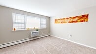 Located at 1603 Patricia Dr in Yeadon, PA, this two-bedroom, one-bathroom residence offers a well-organized single-floor layout designed for comfortable everyday living. The floor plan flows efficiently through a hallway connecting the main living areas, two bedrooms, kitchen, and bathroom.

The spacious primary bedroom is notably generous in size, featuring wall-to-wall carpeting, a built-in closet with sliding wood-paneled doors, and multiple windows that invite ample natural light. Baseboard heating runs along the walls, ensuring year-round comfort. The second bedroom is similarly appointed with plush carpeting, baseboard heating, and windows overlooking greenery outside.

The kitchen features light wood-look vinyl flooring, white cabinetry, light stone-tone countertops, a stainless steel sink, and an electric range, providing a clean and functional cooking space. The bathroom is finished with wood-look vinyl flooring, a white vanity with under-cabinet storage, an oval mirror, and a shower with curtain enclosure, all set against soft blue-gray walls.

Throughout the unit, neutral taupe and gray tones create a cohesive, understated palette. Carpeted rooms, consistent trim work, and individual climate control via both baseboard heating and a wall-mounted air conditioning unit round out this straightforward and practical residence.