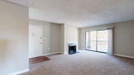 This classic 2-bedroom, 2-bathroom residence at Gleneagle in Columbia, SC offers a practical and comfortable single-floor layout. The living room serves as the heart of the home, highlighted by a wood-burning fireplace and a large sliding glass door that opens to a private balcony, filling the space with natural light and outdoor views. Neutral-toned carpet and a textured ceiling complete the relaxed, classic aesthetic throughout the main living area. The entryway transitions from hardwood-style flooring into the carpeted living room, providing a welcoming arrival experience. The kitchen features warm oak cabinetry, generous counter space with light-toned countertops, and hardwood-style flooring, offering ample storage and prep area. Both bathrooms include tub-shower combinations with tile surrounds, hardwood-style flooring, and white vanities — one featuring a dark granite countertop. The spacious primary bedroom includes a walk-in closet with wire shelving and hanging rods, offering excellent organizational capacity. The second bedroom features a built-in sliding-door closet and plush carpet. A hallway connects the bedrooms and bathrooms, creating an efficient and private layout well-suited for comfortable everyday living.