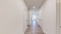 Located at 175 Black St in Rock Hill, SC, this thoughtfully designed 2-bedroom, 3-bathroom home offers a clean, modern aesthetic throughout its single-floor layout. Light wood-style flooring runs through the main living areas and hallway, complemented by crisp white walls and recessed lighting that create a bright, welcoming atmosphere.

The open-concept kitchen and living area serves as the heart of the home. The kitchen features a large central island with a built-in sink, white shaker-style cabinetry with gold hardware, a subway tile backsplash, and stainless steel appliances including a gas range and French door refrigerator. Three bold pendant lights with a matte black and brass finish hang above the island, adding a contemporary touch. A pantry provides additional storage convenience.

The living area flows seamlessly to a private balcony through sliding glass doors, offering outdoor views and natural light. Both bedrooms are carpeted for comfort, with the generously sized primary bedroom including a walk-in closet with built-in wire shelving. The primary bathroom is elegantly finished with large-format white tile flooring, a glass-enclosed shower, and dual vanity with gold hardware accents.

Additional highlights include three well-appointed closets, a dedicated laundry room, a utility room, and consistent matte black hardware details throughout that tie the home's modern design together.
