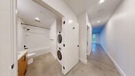 Located at 104 12th Ave in Seattle's vibrant Capitol Hill neighborhood, this modern one-bedroom, one-bathroom unit offers a thoughtfully designed layout with contemporary finishes throughout. Polished concrete floors flow seamlessly across the entire space, lending an industrial-chic aesthetic that complements the clean white walls and recessed lighting.

The open living and kitchen area is a standout, featuring warm wood cabinetry, a classic white subway tile backsplash, stainless steel appliances — including a refrigerator, range, microwave, and dishwasher — and a deep sink. Large windows flood the living area with natural light and frame views of the surrounding cityscape, creating an airy, open ambiance.

The bedroom is a comfortable retreat with its own large window overlooking the city, a ceiling fan, and access to a dedicated closet fitted with built-in shelving and outfitted with a stylish sliding barn door with matte black hardware. The full bathroom is clean and functional, featuring a soaking tub, shower, vanity with wood cabinetry, and a stacked washer and dryer conveniently tucked behind a door in the hallway just outside. The hallways connect all spaces efficiently, completing this well-appointed urban home.