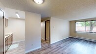 Located at 111 College Hill St in Cheney, WA, this one-bedroom, one-bathroom unit offers a practical and well-organized single-floor layout. The living area features wood-look laminate flooring and a textured ceiling, with two large windows fitted with vertical blinds that allow ample natural light and views of the surrounding greenery. A wall-mounted heating and cooling unit provides year-round climate control, complemented by baseboard heating along the perimeter walls.

A short hallway connects the main living area to the rest of the unit, leading to the bedroom and bathroom. The bedroom is finished with wall-to-wall carpeting, a textured ceiling, and a window with vertical blinds that continues the natural light theme. Baseboard heating runs beneath the window, ensuring comfort throughout the seasons. A dedicated closet provides practical storage within the bedroom.

The bathroom is functional and well-appointed, featuring a wood-toned vanity with a light countertop, a large mirror with overhead lighting, and a tub-shower combination. Light wood-look flooring ties the space together cleanly.

The entryway area offers additional closet access, with dark-toned doors adding contrast to the warm neutral walls throughout the unit. Overall, the space presents a clean, practical layout suited for everyday living.