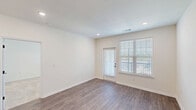 Located in Sanford, NC, this well-appointed single-floor home offers 2 bedrooms and 2 bathrooms with a clean, contemporary design throughout. The open-concept living and kitchen area is anchored by durable wood-look flooring, recessed lighting, and large windows with a glass door that invite abundant natural light and outdoor views. The kitchen is a standout feature, showcasing crisp white shaker cabinetry with matte black hardware, a classic subway tile backsplash, quartz countertops, stainless steel appliances, and a peninsula island with a built-in sink and pendant lighting overhead — ideal for both cooking and casual dining. The living area flows seamlessly from the kitchen, providing a bright, open atmosphere. The primary bedroom is a comfortable retreat with plush carpeting and a ceiling fan, connecting directly to a well-designed en-suite bathroom. The primary bath features wood-look flooring, a dual-sink vanity with quartz countertops and matte black fixtures, and leads to a walk-in closet fitted with wire shelving. The second bedroom also features carpeting, a ceiling fan, and a large window. The second bathroom offers a tiled tub-shower combination with matte black fixtures. Both closets provide ample storage with built-in shelving systems throughout.