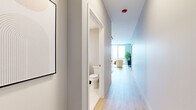 Located in Chicago's vibrant River North neighborhood, this thoughtfully designed one-bedroom, one-bathroom residence offers a seamless blend of modern aesthetics and functional living. Light hardwood floors flow throughout, complementing the clean, neutral palette that defines the space.

The open-concept kitchen and living area serves as the heart of the home. The kitchen features sleek wood-grain cabinetry, a textured tile backsplash, stone countertops, stainless steel appliances, and track lighting overhead. A mobile island with a marble-style top provides additional workspace and casual dining flexibility. The adjacent living room is anchored by dramatic floor-to-ceiling windows that frame sweeping views of the Chicago skyline, flooding the space with natural light.

The bedroom is a comfortable retreat, also benefiting from large windows with city views, light hardwood flooring, and ample wardrobe storage. The bathroom is finished with clean, large-format tile throughout and features a frameless glass-enclosed walk-in shower with chrome fixtures, conveying a spa-like quality.

A well-proportioned entry hallway connects the rooms with an efficient layout. The overall ambiance is contemporary and bright, with a cohesive design language that prioritizes natural light, open sightlines, and modern materials throughout.
