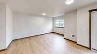 Located at 1360 Wendell Ave SE in Port Orchard, Washington, this well-appointed single-floor residence offers 2 bedrooms and 3 bathrooms within a thoughtfully designed layout. The open-concept living and dining area is a bright, welcoming space featuring light wood-tone flooring, recessed lighting, and large windows that draw in natural light and frame views of the surrounding Pacific Northwest landscape. A glass door provides direct access to an outdoor balcony area, further connecting the interior to the outdoors.

The kitchen is fitted with contemporary gray cabinetry, white countertops, stainless steel appliances including a refrigerator, electric range, and built-in microwave, and a peninsula that serves as both a workspace and casual dining counter. An adjacent walk-in pantry offers generous storage.

Both bedrooms feature plush carpet flooring, natural light from windows, and dedicated closet space with built-in shelving and hanging rods. The primary bedroom is comfortably sized with ample room for furnishings. Three full bathrooms include tub/shower combinations, light wood flooring, and clean white finishes. Additional highlights include a dedicated laundry area, a hallway connecting the private and shared spaces, and abundant closet storage throughout.