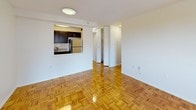 Located at 175 Freeman St in Brookline, MA, this single-floor unit offers a thoughtfully designed layout with a clean, functional aesthetic throughout. The living area is a standout feature, showcasing warm, polished parquet wood flooring in a classic herringbone-style pattern that runs throughout the space. A window with an in-unit air conditioning unit allows natural light to fill the room, creating a bright and welcoming atmosphere.

The kitchen is efficiently designed and connected to the living area via a pass-through opening, enhancing the open feel of the space. It is outfitted with dark espresso cabinetry, granite countertops, a white subway tile backsplash, and stainless steel appliances including a refrigerator, dishwasher, and gas range.

The bedroom continues the parquet flooring theme and includes a built-in closet with bifold doors, providing ample storage. A window with an air conditioning unit overlooks the surrounding neighborhood, offering natural light and ventilation.

The bathroom is finished in a clean, all-white palette with tile flooring, a vanity with counter space, a toilet, and a full tub/shower combination with white ceramic tile surround. The overall layout is practical and well-organized, making effective use of the available space throughout.