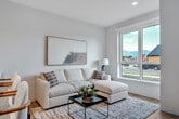 Located at 1810 N 25th Ave in Bozeman, Montana, this thoughtfully designed one-bedroom, one-bathroom unit offers a clean, modern aesthetic throughout its efficiently arranged single-floor layout. Light hardwood flooring flows seamlessly from the entrance through the living areas, creating a warm and cohesive feel. The kitchen is a standout feature, showcasing light wood cabinetry extending to the ceiling, stainless steel appliances including a gas range, microwave, refrigerator, and dishwasher, all centered around a bright white peninsula countertop ideal for casual dining or meal prep. The living room is bathed in natural light from a large picture window that frames views of the surrounding neighborhood, creating an inviting and airy atmosphere. The bedroom is a comfortable retreat with its own window for natural light and an adjacent dedicated closet for ample storage. The bathroom is finished in a crisp, minimalist style featuring a single-vanity with light wood cabinetry, white countertop, tile flooring, and a glass-enclosed walk-in shower with white tile surround. A dedicated laundry area adds everyday convenience. Clean white walls and recessed lighting throughout reinforce the unit's contemporary character.
