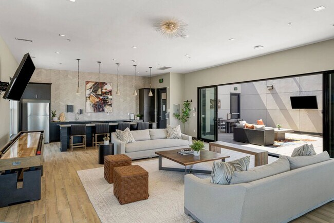 Adéntrate en el acogedor salón de Flats on Archer, donde el diseño moderno se une a la comodidad. La luz natural inunda el espacio, creando un ambiente cálido perfecto para socializar o relajarse. ¡Descubre tu nuevo estilo de vida hoy mismo! - Flats on Archer