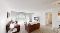 Located at 416 Hollow Creek Rd in Lexington, KY, this single-floor, one-bedroom, one-bathroom residence offers a well-organized layout across a comfortable footprint. The living room serves as the heart of the home, featuring plush carpeting, neutral walls, and large sliding glass doors dressed with vertical blinds that flood the space with natural light and provide access to outdoor views. Adjacent to the living room, a dedicated dining area offers a seamless transition for everyday living and entertaining. The kitchen is outfitted with warm wood cabinetry, light countertops, a double-basin sink, and white appliances including a range and refrigerator, all complemented by durable wood-look flooring. The bedroom is a calm retreat with carpeted floors, a double-door closet, and a window that brings in natural light. Two additional closets throughout the unit provide generous storage. The bathroom features wood-toned cabinetry, a single vanity with a lighted mirror, and a tub-shower combination with clean white surrounds. A hallway connects the rooms efficiently, and an entrance foyer welcomes residents upon arrival. The overall ambiance is clean, bright, and move-in ready.