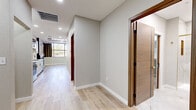 Located at 1645 S 101st E Ave in Tulsa, Oklahoma, this thoughtfully designed one-bedroom, one-bathroom unit offers a comfortable and modern living experience across a single floor. Light wood-style flooring flows seamlessly throughout, creating a clean, cohesive aesthetic.

The open-concept kitchen and living area serves as the heart of the home. The kitchen is outfitted with stainless steel appliances, white lower cabinetry accented with gold hardware, wood-toned upper cabinets, a white subway tile backsplash, and a sleek countertop — all contributing to a contemporary, functional design. The living room features a striking tray ceiling with recessed lighting, a modern electric fireplace set against a stacked stone accent wall, and large windows dressed with floor-length drapes that invite natural light and outdoor views.

The spacious primary bedroom provides a tranquil retreat, complete with recessed lighting, a rich wood-toned door, and a small accent window. A dedicated closet offers additional storage.

The bathroom is a standout feature, finished with large-format marble-look floor and wall tiles, a frameless glass walk-in shower with gold fixtures, a floating vanity, and refined, upscale detailing throughout. The overall ambiance of this unit is clean, modern, and move-in ready.