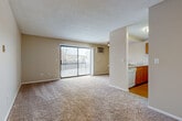 Located at 1551 Fairway Dr in Naperville, IL, this 2-bedroom, 2-bathroom residence offers a well-organized single-floor layout designed for comfortable everyday living. The open-concept living room is a welcoming space, featuring warm neutral tones, plush wall-to-wall carpeting, a textured ceiling, and a ceiling fan. A full-width sliding glass door floods the room with natural light and opens onto a private balcony with outdoor views, making it a bright and inviting gathering area. The adjacent kitchen is efficiently laid out with warm wood cabinetry, light laminate countertops, a white appliance suite, and hardwood-style flooring that adds a contrasting warmth to the space. The primary bedroom is generously sized, offering ample room with soft carpeting, a large closet with wire shelving, and a window that brings in natural light. The second bedroom is equally comfortable, also carpeted and well-lit. Both bathrooms are clean and functional, each featuring a full tub-shower combination with white tile surround. A dedicated in-unit laundry room houses a full-size washer and dryer alongside the water heater. This residence provides a practical and cozy living environment in a desirable Naperville location.