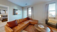 This well-appointed 2-bedroom, 2-bathroom residence in Santa Fe, New Mexico offers a thoughtfully designed single-floor layout with modern finishes throughout. The open-concept kitchen and living area serves as the heart of the home, where a sleek white kitchen with shaker-style cabinetry, subway tile backsplash, quartz countertops, and stainless steel appliances—including a French door refrigerator, electric range, and microwave—flows seamlessly into the living space. A large waterfall-edge island with bar seating and stylish cylindrical pendant lighting anchors the kitchen. The living room features light wood-look flooring, neutral walls, and windows that invite natural light, creating a warm and inviting atmosphere. Both bedrooms are carpeted and well-sized, with the primary bedroom offering a ceiling fan, ample natural light, and access to a dedicated walk-in closet. The bathrooms are finished with white vanities, matte black hardware, and tiled tub-shower combinations. A dedicated in-unit laundry room houses a full-size washer and dryer. The consistent use of light tones, black accents, and wood-look flooring throughout gives the residence a cohesive, contemporary aesthetic.