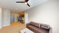 Located at 353 Vine St in West Lafayette, Indiana, this well-appointed two-bedroom, two-bathroom unit offers a thoughtfully designed single-floor layout. The open-concept living and kitchen area serves as the heart of the space, featuring light wood-tone flooring, neutral walls, and a ceiling fan that enhances the airy feel. The kitchen is outfitted with warm wood cabinetry, white quartz countertops, a black matte faucet, and a full suite of stainless steel appliances including a refrigerator, electric range, microwave, and dishwasher. A wall-mounted TV anchors the living area, which receives natural light through a window overlooking the exterior. The two bedrooms are carpeted for comfort, with the primary bedroom offering a closet and natural light from a window. In total, the unit includes three closets for ample storage. Both bathrooms are finished in neutral tones, with one featuring a full soaking tub and shower combination. A dedicated laundry area with a stacked washer and dryer adds everyday convenience. The unit is accessed through a modern, keypad-equipped entry door, reflecting the contemporary design sensibility carried throughout the space.
