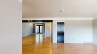 This single-floor unit in Royal Oak, Michigan offers a well-organized layout across a comfortable footprint. The living room is a standout space, featuring warm hardwood flooring that extends throughout the main areas, a bold exposed beam accent, and a set of classic French doors that frame the entryway and invite natural light into the room. A large picture window with vertical blinds further brightens the living area, creating an open and airy atmosphere.

The kitchen is efficiently designed in a U-shaped layout, equipped with dark cabinetry featuring contrasting trim, light countertops, a stainless steel sink beneath a window with outdoor views, and black appliances including a gas range and refrigerator. Track lighting overhead ensures the space is well-lit.

The bedrooms are carpeted for comfort, with the primary bedroom featuring a ceiling fan with light fixture and a closet with dark-paneled doors. The consistent use of bold black doors and trim throughout the unit gives the space a cohesive, modern-industrial character.

The bathroom includes a tiled tub-shower combination with a curved curtain rod, a window for natural light, a white vanity with sink, and hardwood flooring.