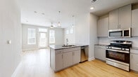 Located in Leander, TX, this generously sized one-bedroom, one-bathroom unit offers a thoughtfully designed open-concept layout with modern finishes throughout. The combined kitchen and living area serves as the heart of the home, featuring light hardwood-style flooring, recessed and pendant lighting, and a ceiling fan. Large windows with plantation shutters fill the space with abundant natural light, while a glass-panel door opens to a private balcony with open sky views.

The kitchen is equipped with sleek gray cabinetry, granite countertops, a white subway tile backsplash, and a full suite of stainless steel appliances including a gas range, microwave, dishwasher, and refrigerator. A kitchen island provides additional counter space and casual seating.

The bedroom is carpeted for comfort and includes a ceiling fan, a bright window with blinds, and direct access to a spacious walk-in closet outfitted with multiple hanging rods and shelving. The full bathroom features gray vanity cabinetry, granite countertops, a large framed mirror with overhead lighting, upper storage cabinets, and marble-style tile accenting the walls, creating a clean and polished aesthetic throughout.