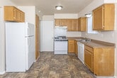 This three-floor residence on Grantour Court in Pontiac, Michigan, offers a practical and well-organized layout across its levels. The kitchen is equipped with warm oak cabinetry providing ample storage, dark laminate countertops, and white appliances including a gas range, dishwasher, and refrigerator. Stone-look tile flooring runs throughout the kitchen, adding durability and visual texture. Natural light enters through windows dressed with vertical blinds, and a door provides convenient exterior access directly from the kitchen area.

The living areas feature neutral wall tones and plush wall-to-wall carpeting, creating a comfortable atmosphere. Built-in shelving near the entryway adds functional storage, while windows allow natural light to brighten the space. Bedrooms are generously sized with carpeted floors, large windows, and spacious walk-in style closets featuring full-width shelving and hanging rods for organized storage.

The bathroom includes a vanity with cabinet storage, stone-look tile flooring, a tiled tub-and-shower combination, and a window that introduces natural light. The unfinished basement offers open utility space with exposed mechanical systems, painted concrete floors, and white-painted walls, presenting potential for future development or storage use.