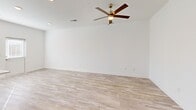 This two-story home in Union City, Georgia offers a clean, modern aesthetic with a cohesive design carried throughout both floors. Light wood-look flooring runs through the main living areas, complemented by crisp white walls and abundant natural light from large, blinds-fitted windows. The main floor hosts an open living room with a ceiling fan and a well-appointed kitchen featuring two-tone cabinetry — white upper cabinets paired with gray lower cabinets — quartz countertops, a subway tile backsplash, and stainless steel appliances including a refrigerator, range, and built-in microwave. An attached garage with an automatic opener provides convenient covered parking. Upstairs, two bedrooms offer ceiling fans, natural light, and generous closet space, including a walk-in closet with built-in shelving and windows. The primary bedroom includes direct access to its own bathroom. The home includes three full bathrooms total: one features a glass-enclosed walk-in shower with chrome fixtures and a gray vanity, while another offers a full tub-shower combination. The overall ambiance is bright, neutral, and move-in ready, with a consistent modern finish throughout.
