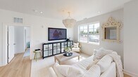 Located on Liberty Street in Pawcatuck, CT, this well-appointed 2-bedroom, 2-bathroom single-floor residence offers a thoughtfully designed layout with clean, modern finishes throughout. The open-concept kitchen is a standout feature, showcasing crisp white cabinetry, granite countertops, stainless steel appliances, and a curved peninsula with seating — ideal for casual dining and entertaining. Light hardwood flooring flows through the main living areas, complementing the bright, white-painted walls and recessed lighting overhead. The living room offers a comfortable, airy atmosphere, anchored by a decorative chandelier and large windows that invite natural light and outdoor views. A dedicated dining area with additional windows further enhances the home's connection to natural light. The generously sized primary bedroom features woven accent wall trim, a walk-in closet, and direct access to an en-suite bathroom. A second bedroom, bathed in natural light from a large window and accented with a candelabra-style chandelier, provides a serene and stylish retreat. Both bathrooms are finished with granite vanity countertops and clean tile work. A connecting hallway ties the layout together, creating a cohesive and functional flow throughout the home.