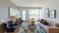 Located at 10826 Austin St NE in Blaine, Minnesota, this single-floor residence offers a well-designed layout with a bright, open feel throughout. The living room is a standout space, bathed in natural light from large windows and a sliding glass door that frames serene waterfront views, creating a welcoming and airy atmosphere. Warm hardwood-style flooring runs through the main living areas, complementing the neutral color palette.

The kitchen is thoughtfully appointed with warm maple cabinetry, granite countertops, a full suite of white appliances including a range, dishwasher, refrigerator, and microwave, and a breakfast bar island that provides additional seating and prep space. Recessed lighting adds a polished finish to the space.

The primary bedroom features plush carpeting, a closet, and direct access to an en-suite bathroom with a vanity, toilet, and tub-shower combination. A second bedroom also offers carpeted floors and ample closet storage. A second full bathroom mirrors the clean, functional design of the first. The convenience of an in-unit washer and dryer adds to the practicality of this well-appointed residence. Overall, the space balances comfort and functionality with appealing waterfront-adjacent surroundings.