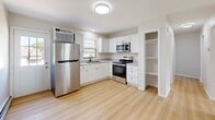 Located at 2011 3rd Ave SE in Aberdeen, South Dakota, this clean and efficiently designed 2-bedroom, 1-bathroom home offers a thoughtful single-floor layout with a bright, cohesive aesthetic throughout. Light wood vinyl flooring runs continuously across all rooms, giving the space a fresh and unified feel.

The living room is a welcoming, open area filled with natural light from a wide multi-pane window that looks out onto greenery. A baseboard heating system is present throughout the home, ensuring year-round comfort. The living area flows naturally into the combined dining room and kitchen, which is connected via a pass-through window opening—ideal for casual interaction between spaces.

The kitchen features white shaker-style cabinetry, granite-look countertops, stainless steel appliances including a refrigerator, electric range, and microwave, as well as a sink with a modern faucet beneath a window. A built-in open shelving unit adds practical storage.

The bathroom is well-appointed with large-format tile surrounding a soaking tub and shower, complete with matte black fixtures, a window for natural ventilation, and light wood flooring.

Both bedrooms are comfortably sized with neutral walls, ample closet storage featuring bi-fold doors, and continued light flooring. The primary bedroom includes a window with an outdoor view. A hallway connects the main living areas to the bedrooms, with two closets providing additional storage.