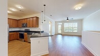 Located at 357 Windigrove Dr in Waynesboro, VA, this two-story residence offers a thoughtfully designed layout spread across two levels. The main living floor hosts the majority of the space, featuring an open-concept kitchen and living room that creates a bright, connected atmosphere. The kitchen is well-appointed with warm wood cabinetry, dark granite countertops, a central island with a sink, stainless steel appliances including a refrigerator, electric range, dishwasher, and microwave, all complemented by hardwood-style flooring. Pendant lighting above the island adds a stylish touch. An elegant arched passageway connects the kitchen to the spacious living area, which is bathed in natural light from large windows and a glass door offering outdoor views. A ceiling fan enhances comfort throughout. The bedroom features plush carpeting, a ceiling fan, a generous window with outdoor views, and access to multiple closets. The full bathroom includes a soaking tub and shower combo with clean, neutral finishes. A dedicated laundry room houses a full-size front-loading washer and dryer. The entry level provides additional staircase access. With four closets and a practical hallway, this residence delivers both comfort and functionality in a clean, modern setting.