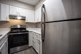 Located at 1920 Bowater Dr in Kingsport, Tennessee, this single-floor unit offers a clean, updated interior with a cohesive neutral color palette throughout. The living area features light gray luxury vinyl plank flooring, crisp white baseboards, and warm beige walls, creating a bright and welcoming atmosphere. Natural light filters in through window blinds, enhancing the open feel of the space.

The kitchen is well-appointed with bright white shaker-style cabinetry, sleek brushed nickel hardware, light quartz countertops, and a stainless steel electric range with a matching range hood — offering both function and a modern aesthetic.

Multiple rooms feature the same durable LVP flooring and neutral wall tones, with windows providing views of the surrounding neighborhood. Each room benefits from ceiling ventilation and ample electrical outlets, reflecting practical, move-in-ready design.

The bathroom includes a full tub and shower combination with white tile surround, a curved shower rod, and coordinating brushed nickel fixtures and accessories. The flooring continues the consistent LVP theme found throughout the unit.

The 3D floorplan reveals a compact yet efficiently arranged layout, with a utility area housing a water heater. Overall, this space presents a freshly updated, functional living environment in a residential Kingsport neighborhood.