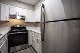Located at 1920 Bowater Dr in Kingsport, Tennessee, this single-floor unit offers a clean, updated interior with a cohesive neutral color palette throughout. The living area features light gray luxury vinyl plank flooring, crisp white baseboards, and warm beige walls, creating a bright and welcoming atmosphere. Natural light filters in through window blinds, enhancing the open feel of the space.

The kitchen is well-appointed with bright white shaker-style cabinetry, sleek brushed nickel hardware, light quartz countertops, and a stainless steel electric range with a matching range hood — offering both function and a modern aesthetic.

Multiple rooms feature the same durable LVP flooring and neutral wall tones, with windows providing views of the surrounding neighborhood. Each room benefits from ceiling ventilation and ample electrical outlets, reflecting practical, move-in-ready design.

The bathroom includes a full tub and shower combination with white tile surround, a curved shower rod, and coordinating brushed nickel fixtures and accessories. The flooring continues the consistent LVP theme found throughout the unit.

The 3D floorplan reveals a compact yet efficiently arranged layout, with a utility area housing a water heater. Overall, this space presents a freshly updated, functional living environment in a residential Kingsport neighborhood.