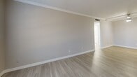 Located at 1304 Raider Dr in Euless, TX, this single-story 1-bedroom, 1-bathroom home offers a thoughtfully organized layout with modern, clean finishes throughout. Light wood-style flooring runs consistently across the living spaces, creating a cohesive and bright aesthetic. The combined living and dining area is generously proportioned, featuring crown molding, neutral gray walls, and a ceiling fan overhead, lending the space an open and comfortable feel. Natural light filters in through blinds-covered windows, enhancing the airy ambiance. The kitchen is well-appointed with white shaker-style cabinetry, crisp quartz countertops, a stainless steel sink, and a classic white subway tile backsplash. Black appliances, including a refrigerator and range, add a bold contrast to the bright surroundings. The spacious primary bedroom includes a ceiling fan, a window with an exterior view, and access to two closets, offering ample storage. A hallway connects the living areas to the bedroom and bathroom, which features a clean, all-white tub-shower surround with built-in shelving niches and chrome fixtures. A dedicated laundry area completes the functional layout of this well-maintained Euless home.
