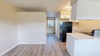 Located at 4004 S Manhattan Ave in Tampa, FL, this efficiently designed one-bedroom, one-bathroom unit offers a smart, open-concept layout across a single floor. Wood-look laminate flooring flows throughout the entire space, providing a cohesive and easy-to-maintain surface.

The combined dining, kitchen, and living area maximizes the available footprint. The kitchen features white cabinetry, a clean white countertop with a peninsula that doubles as a dining surface, a black refrigerator, and a sink with a window view. A wall-mounted mini-split unit provides climate control. Track lighting and a window at the far end of the living area allow natural light to brighten the space.

The bedroom is a well-proportioned room with a window that brings in natural light, a textured ceiling, and direct access to a dedicated closet equipped with sliding double doors — offering practical storage for the space.

The bathroom is finished in a light, neutral palette with wood-look tile flooring, a single-sink vanity with storage cabinetry, a large mirror with a lighted bar fixture above, and a tub-shower combination with tiled surround.

Overall, the unit presents a clean, updated aesthetic with a functional layout well-suited for efficient single-occupant living in South Tampa.