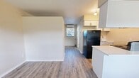 Located at 4004 S Manhattan Ave in Tampa, FL, this efficiently designed one-bedroom, one-bathroom unit offers a smart, open-concept layout across a single floor. Wood-look laminate flooring flows throughout the entire space, providing a cohesive and easy-to-maintain surface.

The combined dining, kitchen, and living area maximizes the available footprint. The kitchen features white cabinetry, a clean white countertop with a peninsula that doubles as a dining surface, a black refrigerator, and a sink with a window view. A wall-mounted mini-split unit provides climate control. Track lighting and a window at the far end of the living area allow natural light to brighten the space.

The bedroom is a well-proportioned room with a window that brings in natural light, a textured ceiling, and direct access to a dedicated closet equipped with sliding double doors — offering practical storage for the space.

The bathroom is finished in a light, neutral palette with wood-look tile flooring, a single-sink vanity with storage cabinetry, a large mirror with a lighted bar fixture above, and a tub-shower combination with tiled surround.

Overall, the unit presents a clean, updated aesthetic with a functional layout well-suited for efficient single-occupant living in South Tampa.