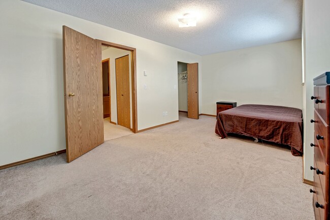 A bedroom with a large closet and overhead lighting - Ridgeview Village