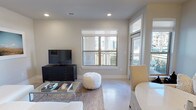 This single-floor, 2-bedroom, 2-bathroom residence offers a thoughtfully designed open-concept layout with modern finishes throughout. The living area is bright and welcoming, featuring recessed lighting, neutral tones, and large windows that invite natural light and outdoor views, with direct access to an outdoor space. The kitchen is a standout feature, equipped with stainless steel appliances including a French door refrigerator, electric range, microwave, and dishwasher. Crisp white cabinetry extends to the ceiling for generous storage, while a central island with a dark quartz countertop provides additional prep space and casual seating. A classic subway tile backsplash adds a clean, timeless touch. Both bedrooms are generously sized with ample natural light from multiple windows. The primary bedroom includes dual windows and a serene, neutral palette. The second bedroom features a ceiling fan, direct outdoor access, and views of the surrounding greenery. The two bathrooms are finished with white cabinetry and chrome fixtures, with one featuring a soaking tub framed by white subway tile. Throughout, light flooring and a consistent neutral color palette create a cohesive, modern ambiance ideal for comfortable everyday living.