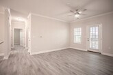 This single-story residence on Scots Pine Run in North Chesterfield, Virginia, offers a thoughtfully designed open-concept layout with contemporary finishes throughout. The living area is anchored by light-toned hardwood-style flooring, crown molding, and a ceiling fan, creating a bright and welcoming atmosphere. Large windows and a glass-paned exterior door allow natural light to flow freely into the space.

The kitchen is a functional centerpiece, featuring dark espresso cabinetry, granite countertops, a peninsula with an undermount sink, pendant lighting, and black stainless steel appliances including a refrigerator, range, microwave, and dishwasher. The open sightlines between the kitchen and living area make the layout ideal for everyday living.

The bedrooms are carpeted and generously sized, each equipped with ceiling fans and ample closet space. Several bedrooms include walk-in closets with built-in wire shelving, while additional rooms feature double reach-in closets. Windows in each bedroom provide natural light and outdoor views.

The bathrooms are finished with dark wood vanities, white countertops, large mirrors, and light hardwood-style flooring. Tub-shower combinations are tiled in crisp white, accented by brushed nickel fixtures, completing the clean, modern aesthetic of the home.