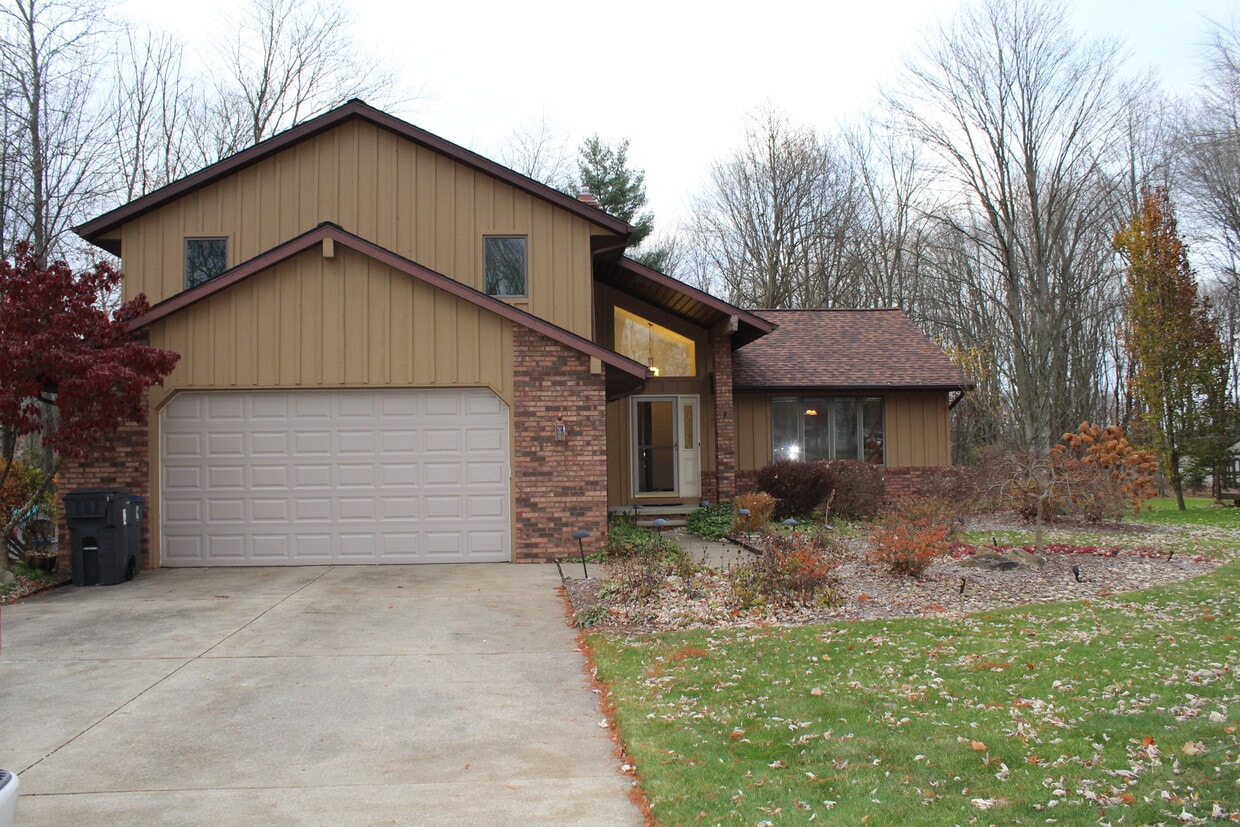 Charming split-level home with brick-and-wood exterior, attached two-car garage, and great curb appe - 6235 Sunnywood Dr