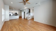 This two-floor home offers a well-designed layout with modern finishes throughout. The kitchen is a standout feature, equipped with stainless steel appliances including a range, over-the-range microwave, and French door refrigerator. White shaker-style cabinetry pairs elegantly with granite countertops and a mosaic tile backsplash, while a kitchen island with an undermount sink adds both functionality and style. Warm hardwood-style flooring flows continuously throughout the home, creating a cohesive and inviting atmosphere.

The living area is generously proportioned, bathed in natural light from multiple windows, and finished with a ceiling fan and recessed lighting. The bedrooms feature vaulted ceilings that enhance the sense of space, along with windows for natural light and walk-in closets with built-in shelving and hanging rods for ample storage.

The bathrooms are thoughtfully appointed with granite-topped white vanities, undermount sinks, and full tub-shower combinations tiled in distinctive hexagonal marble-style tile. Black penny tile accents add a contemporary touch to the mirror surrounds. Clean neutral wall tones and consistent flooring tie the entire home together in a modern, move-in-ready aesthetic.
