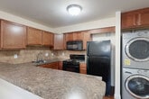 Located at 2619 Hydraulic Rd in Charlottesville, VA, this single-floor, 2-bedroom, 1-bathroom unit offers a functional and well-appointed layout. Warm hardwood-style flooring flows consistently throughout every room, creating a cohesive and inviting atmosphere.

The kitchen is a standout feature, offering rich wood cabinetry, dark granite-style countertops, a tile backsplash, and black appliances including a gas range, microwave, and refrigerator. A peninsula counter connects the kitchen to the living area, and an in-unit washer and dryer are conveniently located adjacent to the kitchen.

Both bedrooms are comfortably sized, each featuring ceiling fans, large windows with blinds that allow natural light, and built-in closets with bi-fold doors. The primary bedroom includes crown molding for an added touch of elegance.

A central hallway connects the bedrooms to the full bathroom, which is outfitted with a tub-shower combination, a wood-vanity with a light countertop, and chrome fixtures. The entryway opens to the living space and features hardwood-style flooring and a keypad-equipped front door. The overall design is clean, neutral, and move-in ready.