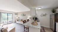 This single-floor residence on Kellogg Woods Dr SE in Kentwood, Michigan offers a thoughtfully designed layout with a neutral, welcoming palette throughout. The open-concept living and kitchen area serves as the heart of the unit, where a granite-topped breakfast bar with bar seating connects the kitchen seamlessly to the carpeted living room. The kitchen is equipped with stainless steel appliances, including a refrigerator and range, complemented by white cabinetry and wood-look vinyl plank flooring. A separate dining area adjacent to the kitchen features a pendant chandelier and provides a dedicated space for meals. The living room is comfortable and well-proportioned, benefiting from natural light and a sliding glass door that opens directly to an outdoor green space. The bedroom offers plush carpeting, a window for natural light, and baseboard heating, providing a quiet and restful environment. The bathroom features a granite-topped vanity with white cabinetry, a framed mirror, and a shower-tub combination. Throughout the space, consistent warm-toned walls, updated fixtures, and coordinated finishes create a cohesive and inviting atmosphere.