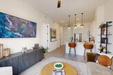 Located at 2825 W 11th St in Houston, TX, this thoughtfully designed one-bedroom, one-bathroom residence offers an efficient yet comfortable single-floor layout. Light-toned hardwood-style flooring and crisp white walls run throughout, creating a bright, cohesive aesthetic.

The open-concept living, dining, and kitchen area forms the heart of the home. The kitchen is outfitted with white shaker cabinets, stainless steel appliances including a French door refrigerator, a farmhouse-style sink, and a sleek white quartz countertop island with bar seating for two. A trio of glass pendant lights adds a modern focal point overhead.

The living room benefits from a large floor-to-ceiling window that invites abundant natural light and provides views of the surrounding neighborhood. A ceiling fan enhances comfort throughout the shared living space.

The primary bedroom is a well-proportioned retreat, also featuring a floor-to-ceiling window with outdoor views, and direct access to the full bathroom. The bathroom includes a glass-enclosed shower and white cabinetry. Additional conveniences include three closets and a dedicated in-unit laundry area, ensuring practical, everyday functionality. The overall ambiance is clean, contemporary, and well-appointed.
