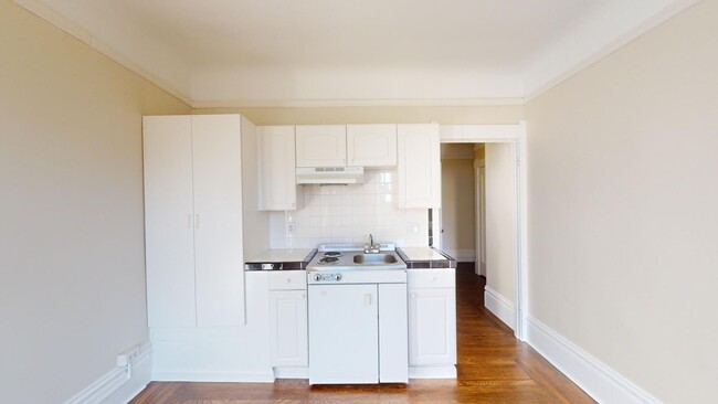 Kitchen with cabinets, stove, range hood, and sink - 925 Geary Street