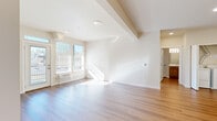Located at 11684 N Standard Dr in Spokane, WA, this well-designed one-bedroom, one-bathroom unit offers a thoughtfully laid-out single-floor plan. The open-concept living area is bathed in natural light from large windows and a glass door that leads to a private balcony, offering views of the surrounding tree line. Light-toned hardwood flooring runs throughout the main living spaces, lending a clean, modern aesthetic to the interior.

The kitchen is a functional centerpiece of the unit, featuring a peninsula with a white countertop that doubles as a breakfast bar with bar seating. Warm wood cabinetry, stainless steel appliances — including a refrigerator, range, and microwave — and a built-in sink with pendant lighting above complete the space with both style and practicality.

The spacious bedroom is carpeted for comfort and includes a large sliding double-door closet, a dedicated window with natural light, and a baseboard heating system. The full bathroom is finished with warm wood vanity cabinetry, a white countertop, a large mirror, and a full tub/shower combo with hardwood-style flooring.

Throughout the unit, clean white walls, exposed ceiling beams in the living area, and consistent warm-toned finishes create a bright, cohesive, and inviting atmosphere.