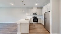 This 630 square foot apartment in Cedar Heights offers a thoughtfully designed living space that maximizes efficiency and comfort. The single-floor layout features one bedroom, measuring 130 square feet, and one bathroom. The heart of the home is an open-concept kitchen and living area, creating a sense of spaciousness within the compact footprint.

Throughout the apartment, warm wood-look flooring adds a touch of elegance and continuity. The neutral color palette, dominated by soft whites and light tones, enhances the bright and airy atmosphere. Large windows, including sliding glass doors in the bedroom, flood the space with natural light and offer views of the surrounding area.

The kitchen boasts modern white cabinetry, sleek stainless steel appliances, and a functional island with a stylish granite countertop. Pendant lighting adds a contemporary touch while providing task lighting for meal preparation.

The bathroom features a glass-enclosed shower, a single vanity with a granite countertop, and ample storage space. The bedroom, while compact, includes a closet for storage and is equipped with a modern ceiling fan for comfort.

Despite its modest size, the apartment doesn't compromise on style or functionality. The layout is well-thought-out, with each area seamlessly flowing into the next, making the most of the available space. This Cedar Heights apartment is an excellent example of how thoughtful design can create a comfortable and inviting home in a compact urban setting.
