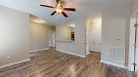 Located at 851 Lynnwood Way in Bowling Green, Kentucky, this single-floor residence offers a practical and comfortable layout finished with consistent, neutral tones throughout. The open living area features durable wood-look plank flooring and a ceiling fan with light fixture, creating a bright and airy atmosphere. A half-wall pass-through connects the living space to the kitchen, which is equipped with warm wood cabinetry, light granite-style countertops, and black appliances including a refrigerator, electric range, and over-the-range microwave. The bedrooms are carpeted for comfort and each include a ceiling fan and window with blinds that allow natural light while maintaining privacy. The primary bedroom connects to a closet and a full bathroom. A second full bathroom is also present, both featuring tub-shower combinations, wood-look tile flooring, and clean white fixtures. One bathroom includes a vanity with wood cabinetry and a large mirror. A utility closet houses the water heater alongside built-in wire shelving for additional storage. The overall design is clean and functional, with a cohesive neutral palette and consistent finishes that provide a move-in ready living environment.