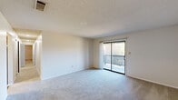 Located at 750 Corder Rd in Warner Robins, Georgia, this two-bedroom, one-bathroom single-floor residence offers a practical and comfortable layout. The living room is a welcoming, carpeted space featuring a textured ceiling and a sliding glass door that opens to a private balcony with a lattice railing, allowing natural light and outdoor views to fill the room. The galley-style kitchen is efficiently designed with ample white cabinetry, wood-toned accents, a double basin sink, a dishwasher, an electric range, and a full-size refrigerator, all set over durable wood-look flooring. The primary bedroom is a generously sized, carpeted retreat with a ceiling fan and a window that provides natural light and outdoor views. The second bedroom is equally well-appointed, also featuring plush carpet, a ceiling fan, and a window. A hallway connects the living areas to the bedrooms and bathroom. The full bathroom includes a shower-tub combination, a toilet, a vanity, and wood-look flooring. Two closets provide additional storage throughout the home. Textured ceilings are consistent across most rooms, contributing to a cohesive aesthetic throughout the residence.