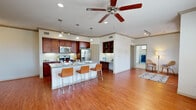 This thoughtfully designed two-story home offers a comfortable and functional layout across its well-utilized floor plan. The main living level is anchored by a spacious open-concept kitchen and living area that immediately impresses with warm hardwood-style flooring, recessed lighting, and a ceiling fan that enhances the airy atmosphere. The kitchen is a standout feature, boasting rich dark wood cabinetry, granite countertops, a classic subway tile backsplash, and a full suite of stainless steel appliances including a refrigerator, microwave, and range. A large central island with seating for multiple bar stools serves as both a prep space and a casual dining hub. A built-in shelving nook and desk area add practical charm to the living space. The generously sized bedroom features plush carpeting, a ceiling fan, multiple windows that invite natural light, and a cozy built-in window seat. The full bathroom includes a soaking tub, tiled surround, a separate glass-enclosed shower, and a granite-topped vanity. A dedicated laundry room houses a full-size washer and dryer with additional shelving for storage. The attached garage with an automatic opener rounds out the home's practical amenities.