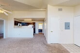 Located at 7929 W Mansfield Pkwy in Lakewood, Colorado, this single-floor, 2-bedroom, 2-bathroom residence offers a well-organized layout designed for comfortable everyday living. The living room serves as the focal point of the home, distinguished by soaring vaulted ceilings and a striking arched window that floods the space with natural light. A fireplace anchors the room, adding warmth and character, while plush carpeting underfoot contributes to a cozy atmosphere. A tiled entryway transitions smoothly into the living area.

The kitchen is positioned adjacent to the living room and features a pass-through counter that maintains visual connectivity between the two spaces. Dark espresso cabinetry contrasts with light countertops, and white appliances — including a range, microwave, and refrigerator — provide full functionality. Wood-look flooring runs throughout the kitchen.

Both bedrooms are carpeted and feature vertical blinds over windows that admit natural light. The generously sized primary bedroom includes access to a closet. The two bathrooms each offer a tub-shower combination with tiled surrounds, wood-look flooring, and dark vanity cabinetry with light countertops, maintaining a consistent design aesthetic throughout the home.