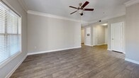 Located in Milton, GA, this well-appointed 2-bedroom, 2-bathroom single-floor home offers a thoughtfully designed layout with quality finishes throughout. The open-concept kitchen and living area serves as the heart of the home, featuring stainless steel appliances including a refrigerator, range, and microwave, complemented by white cabinetry, granite countertops, a breakfast bar with decorative columns, and wood-style flooring. Crown molding and ceiling fans add refined detail to the living spaces.

The dining room receives natural light through a window with blinds and features a pendant light fixture, crown molding, and matching wood-style flooring. The spacious primary bedroom includes a tray ceiling, ceiling fan, plush carpet, and a natural light source, while the walk-in closet offers generous wire-rack shelving. The second bedroom is finished with neutral-toned carpet and clean walls.

Both bathrooms are finished with granite-top vanities and wood-style flooring. One bathroom includes a tiled tub-shower combination with decorative tile accents. A dedicated laundry room houses a full-size washer and dryer with overhead shelving. The welcoming entrance and well-connected hallways round out this functional and comfortable home.