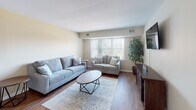 Located at 2726 Jacqueline Dr in Wilmington, Delaware, this single-floor home offers a well-organized and comfortable layout designed for everyday living. The living room is a welcoming space featuring warm hardwood flooring, a large picture window with vertical blinds that invites natural light, and ample room for seating. Adjacent to the living area, the dining space is defined by a pendant light fixture above a dining table, chair rail molding along the walls, and the same hardwood flooring that flows throughout the main areas. The kitchen is efficiently designed with warm-toned cabinetry, granite-style countertops, stainless steel appliances including an electric range and over-the-range microwave, and a double stainless steel sink beneath a window. A hallway connects the main living areas to the private spaces, including two bedrooms. The primary bedroom is generously proportioned, featuring plush carpeting, multiple windows with sheer curtains, a wall-mounted television, and a connected en-suite bathroom. The second bedroom also offers comfortable carpeted flooring and natural light. Two bathrooms serve the home, both finished in neutral tones with clean, functional fixtures. The overall aesthetic is light, neutral, and move-in ready.