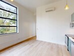 Located at 300 Benedict Dr in Pittsburgh, PA, this thoughtfully designed one-bedroom, one-bathroom unit offers a clean, modern aesthetic throughout its single floor. Light-toned hardwood flooring flows continuously across the entire space, creating a warm and cohesive feel.

The open-concept living, dining, and kitchen area is a standout feature, anchored by a well-appointed kitchen with sage green shaker-style cabinetry, brass hardware, a classic white subway tile backsplash, and a full suite of stainless steel appliances. Pendant lighting with warm-toned bulbs and a multi-arm brass chandelier add character and illumination to this central gathering space. A wall-mounted mini-split system ensures year-round comfort.

The bedroom is particularly impressive, boasting soaring ceilings and a large, bold black-framed window that floods the room with natural light and frames views of surrounding greenery. A mirrored sliding-door closet adds both storage and depth to the room.

The bathroom is elegantly finished with a sage green vanity, white quartz countertop, marble-style tile flooring, and black fixtures throughout, complemented by warm globe vanity lighting for a refined touch.

Additional conveniences include a dedicated laundry area and a closet, rounding out this well-planned and stylishly executed Pittsburgh residence.