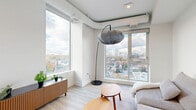 Located in the heart of Ottawa's Centretown neighbourhood, this thoughtfully designed two-bedroom, two-bathroom unit delivers a clean, contemporary aesthetic throughout. Light-toned laminate flooring runs continuously across the single-level floor plan, complementing the crisp white walls and recessed lighting that keep the interior feeling bright and open.

The living room is a standout space, anchored by expansive corner windows that frame sweeping elevated views of the Ottawa skyline and surrounding neighbourhood, flooding the area with abundant natural light. The galley-style kitchen is efficiently laid out with sleek, light-wood cabinetry, white countertops, stainless steel appliances, and a built-in breakfast nook beneath a tall window — a practical yet stylish arrangement.

The primary bedroom benefits from large windows with city views, light hardwood-style flooring, and a sliding-door closet for streamlined storage. The second bedroom is equally well-appointed with its own closet access. Three closets in total provide ample storage throughout the unit. A dedicated laundry area adds everyday convenience.

Both bathrooms are finished in neutral tones; one features wood-look tile surrounding a full soaking tub, offering a spa-like feel. The unit also includes a connecting hallway that links all rooms cohesively, completing this well-organized and modern urban residence.